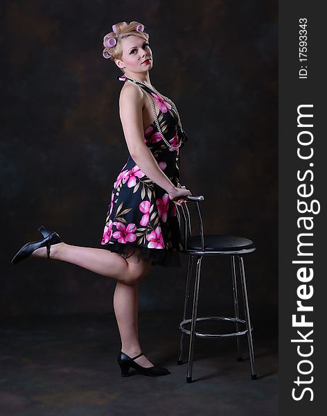 Photograph showing retro style 50s female posing with stool. Photograph showing retro style 50s female posing with stool