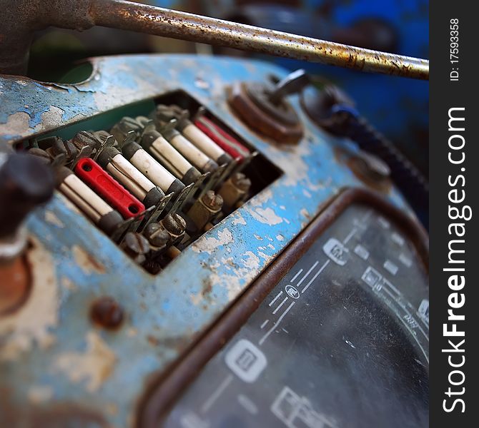 Old tractor dashboard with a key in the ignition and fuse panel.