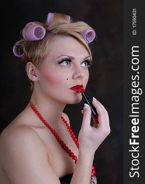 Retro 50s style female putting on lip stick