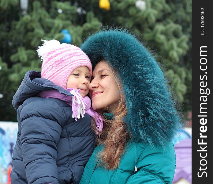 Happi Mom  and girl near a Christmas tree. Happi Mom  and girl near a Christmas tree