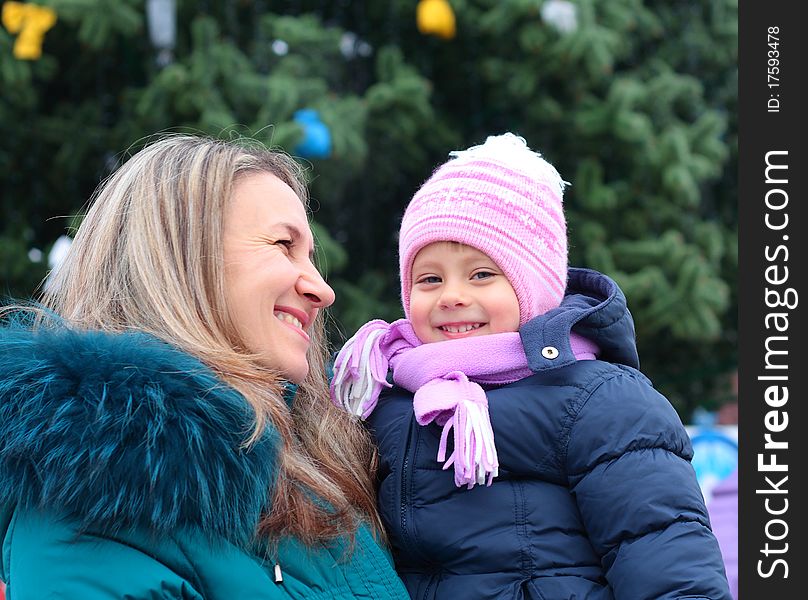 Happi Mom and girl near a Christmas tree