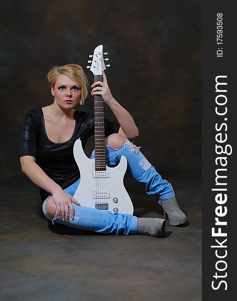 Images showing pretty young female with white electric guitar. Images showing pretty young female with white electric guitar