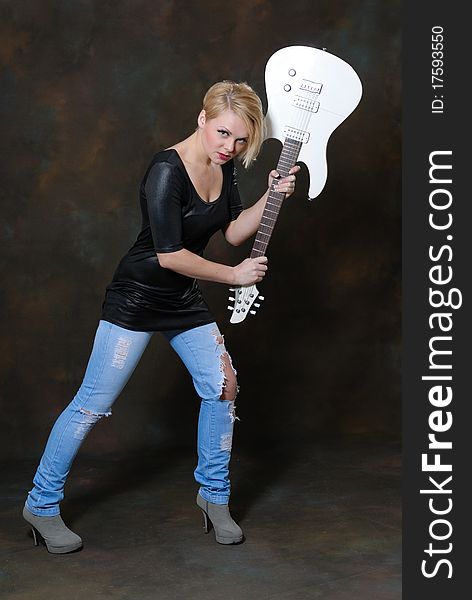 Images showing pretty young female with white electric guitar. Images showing pretty young female with white electric guitar