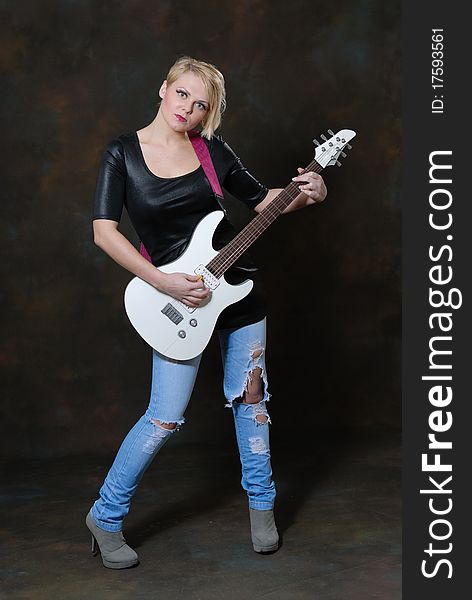 Images showing pretty young female with white electric guitar. Images showing pretty young female with white electric guitar