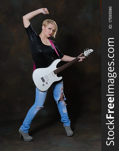 Images showing pretty young female with white electric guitar. Images showing pretty young female with white electric guitar