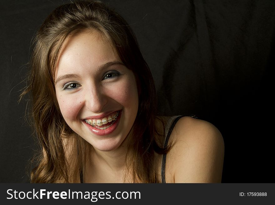 Teenage girl  smiling on black background