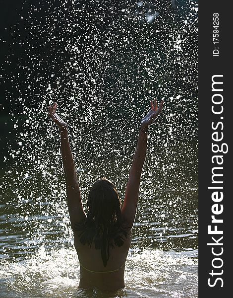 Beautiful young woman enjoying a bath in a lake/river/sea silhouette