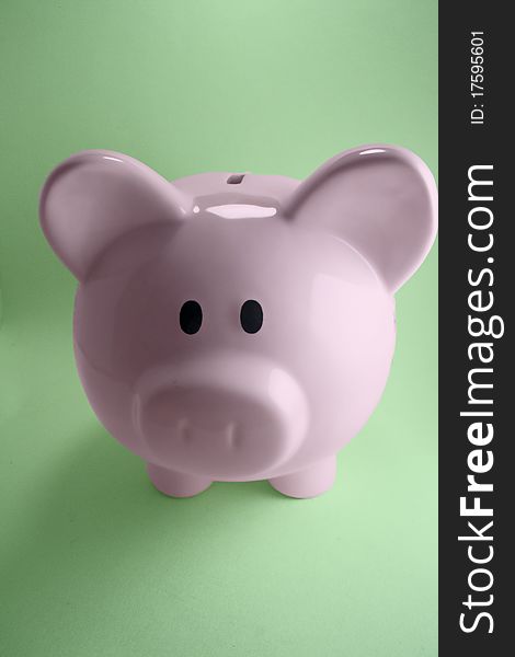 Pink piggy bank with green background.