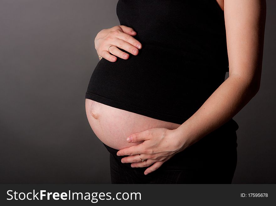 Beautiful pregnant woman staing on grey background