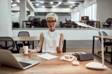Little Break. Young Tattooed Business Woman In Eyewear Holding Cup Of Coffee And Looking At Camera While Working Alone Royalty Free Stock Photos
