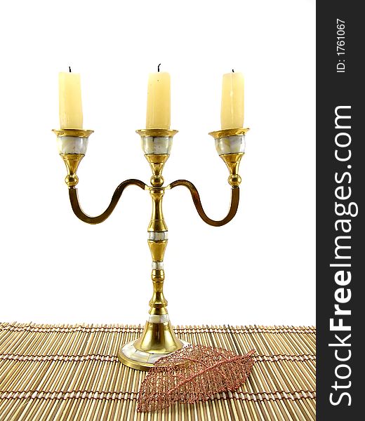 Beautiful candlestick and leaf on a bamboo napkin