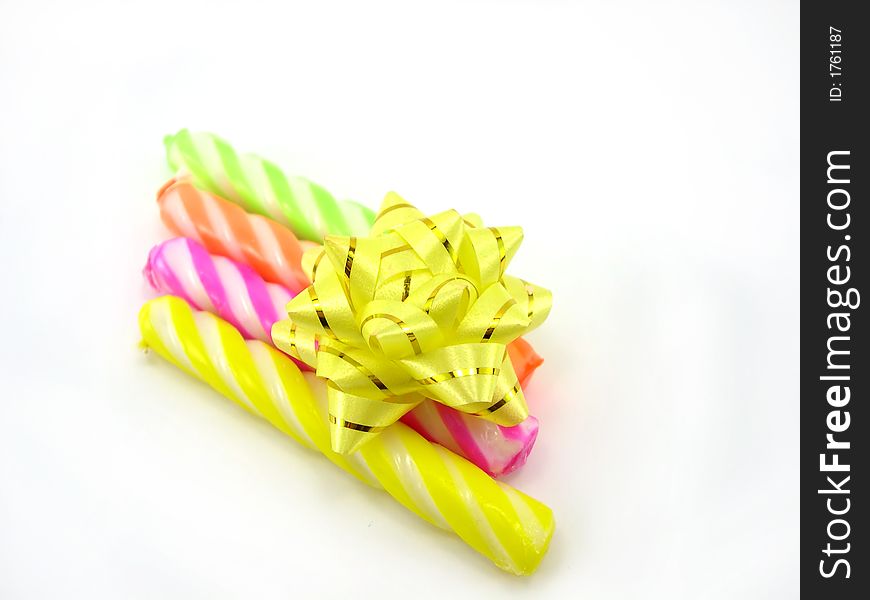 Multi-coloured celebratory candles on a white background