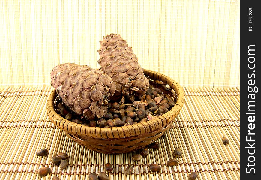 Beautiful cone with nuts on a background of a bamboo napkin