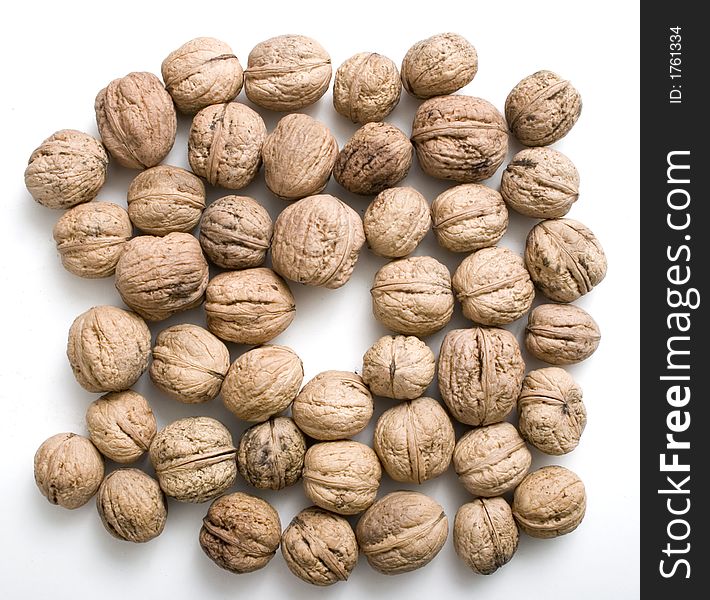 Walnuts background with the free place in the center of image for inserting smth