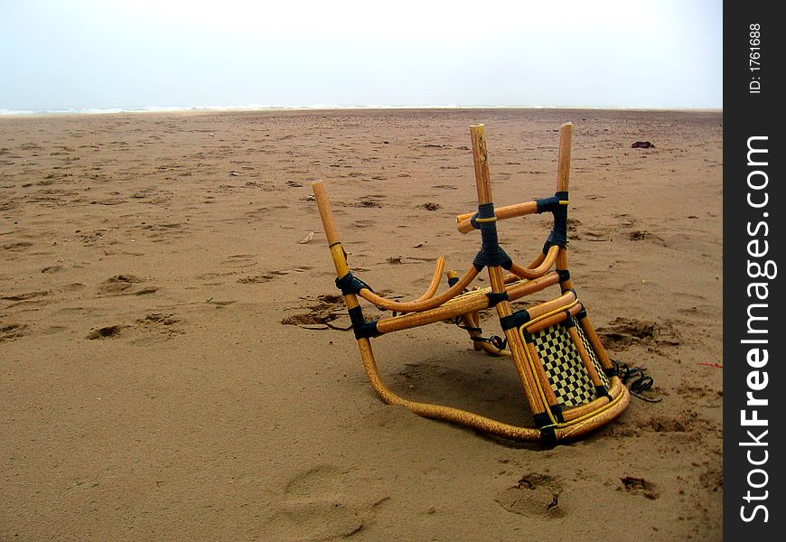 Upturned chair lying on the beach. Upturned chair lying on the beach.