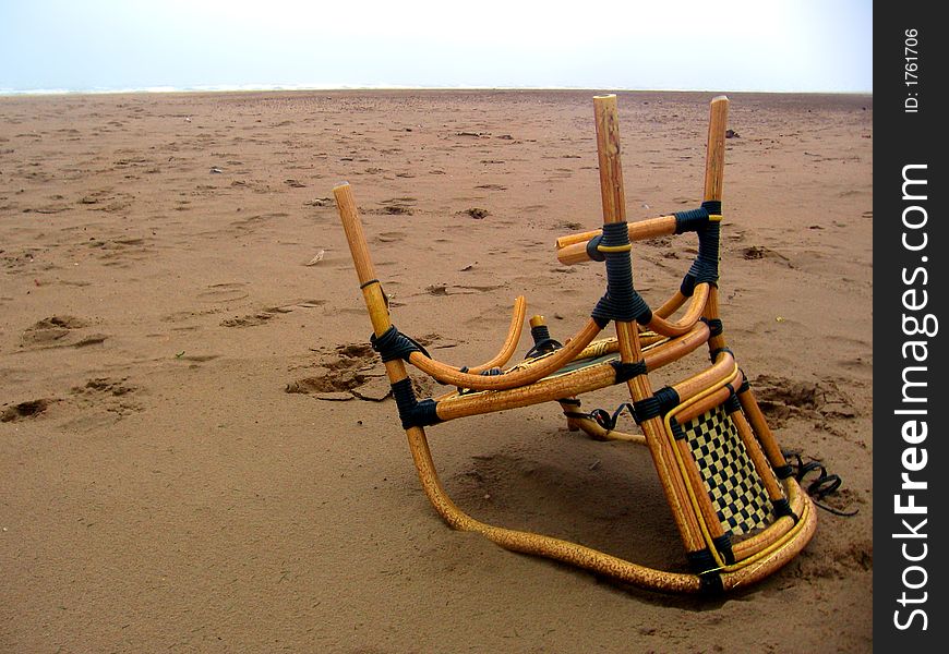 Upturned chair lying on the beach. Upturned chair lying on the beach.