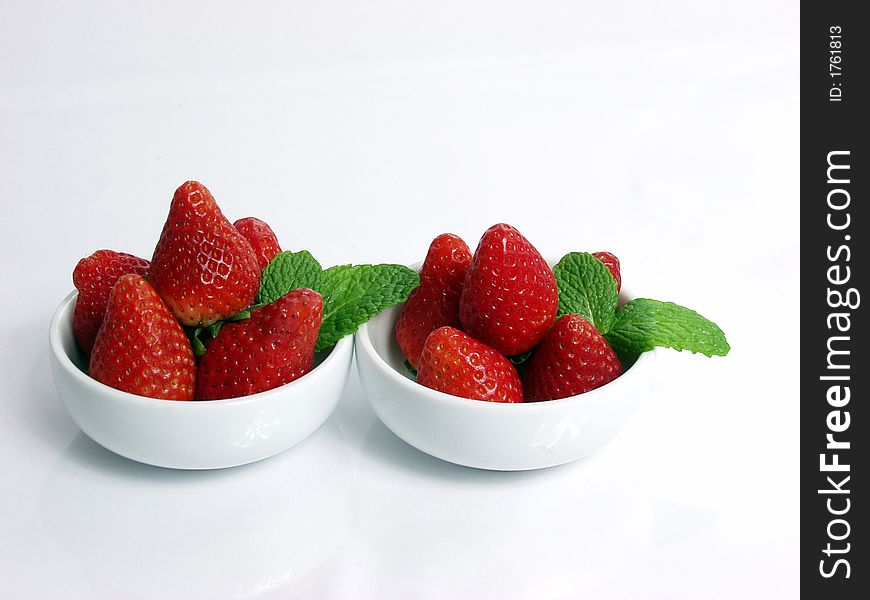 Two strawberry  little  bowl with mint leaves on white background