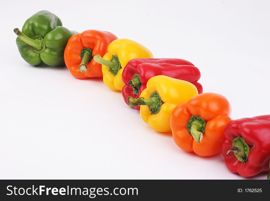 Different colored peppers in a line