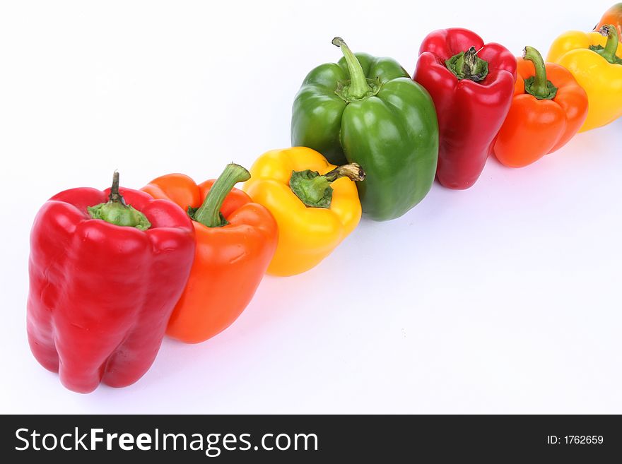 Different colored peppers in a line