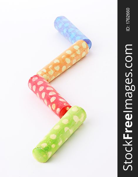 Four sticks of polka dot chalk in a zig zag line