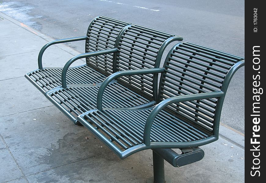 Green city bench from sidewalks of Manhattan.