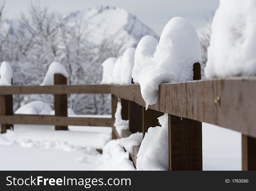 Wooden fence covered with snow in a diagonal prespective
