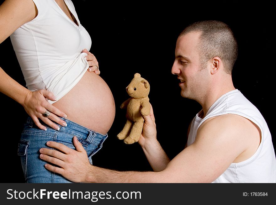 Man playing with the doll in front of the belly. Man playing with the doll in front of the belly