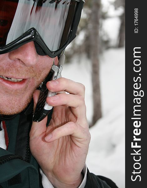 A man uses his cell phone while enjoying the outdoors skiing #3. A man uses his cell phone while enjoying the outdoors skiing #3