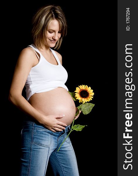 Pregnant woman on black with a sunflower. Pregnant woman on black with a sunflower