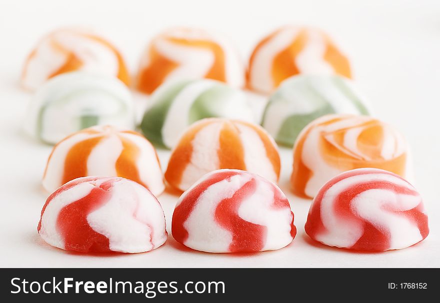 Many not chocolate sweets lay beside close by on white background