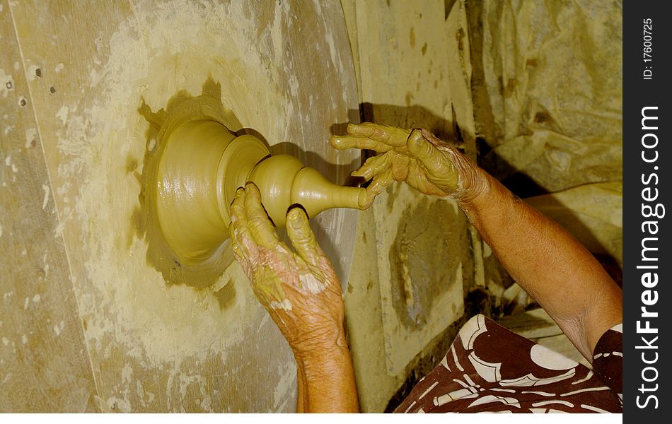 The hands of the potter making a vase in argil .