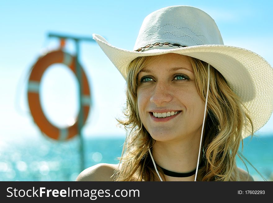 Female lifeguard wearing hat with ring-buoy on the backgroung. Female lifeguard wearing hat with ring-buoy on the backgroung