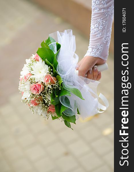 Wedding bouquet in hands of the bride. Blur background.