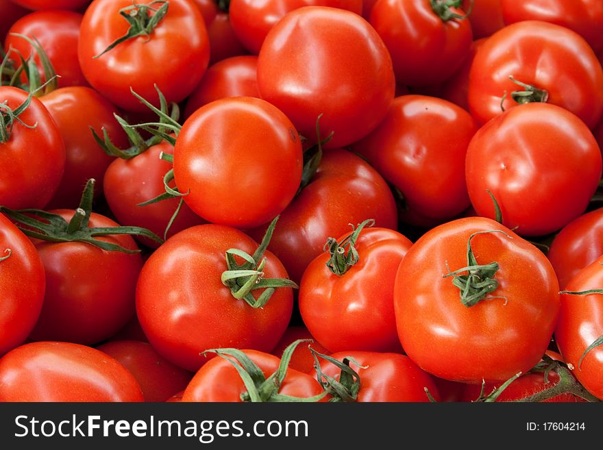 Red ripe tomatoes background with green roots