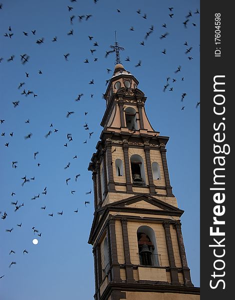 Church steeple at dusk with birds