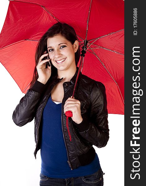 A young woman is standing and talking on the phone while holding an umbrella. A young woman is standing and talking on the phone while holding an umbrella.