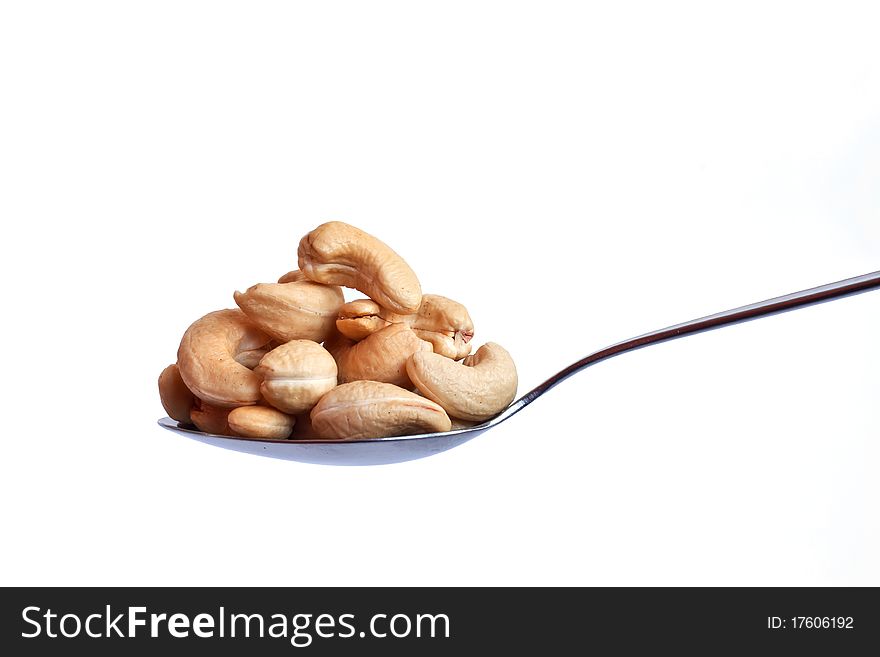 Spoonful of cashew nuts on white background