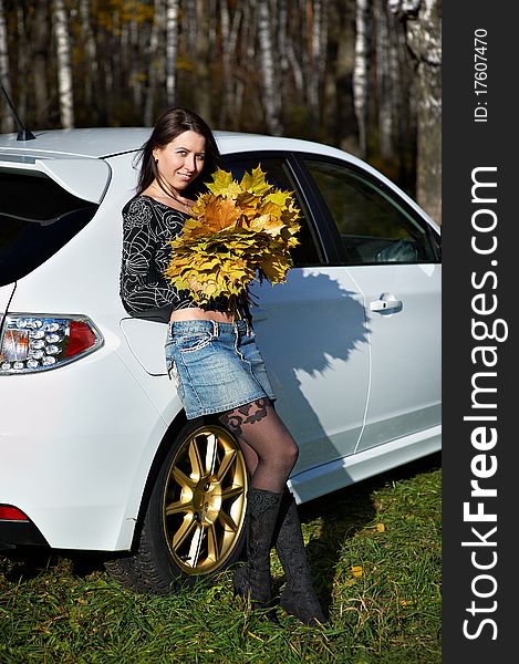 Beauty romantic girl with yellow leaves and white stylish modern car on nature in autumn park. Beauty romantic girl with yellow leaves and white stylish modern car on nature in autumn park