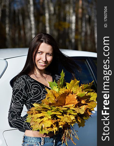 Beauty romantic girl with yellow leaves and white modern car on nature in autumn park. Beauty romantic girl with yellow leaves and white modern car on nature in autumn park