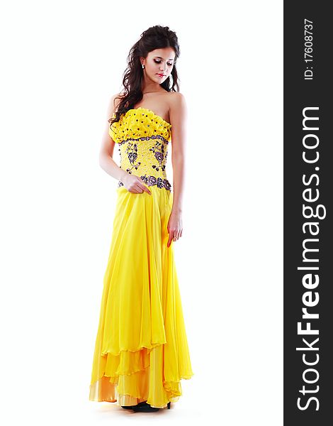 Beautiful young girl posing in yello fashionable dress on white background