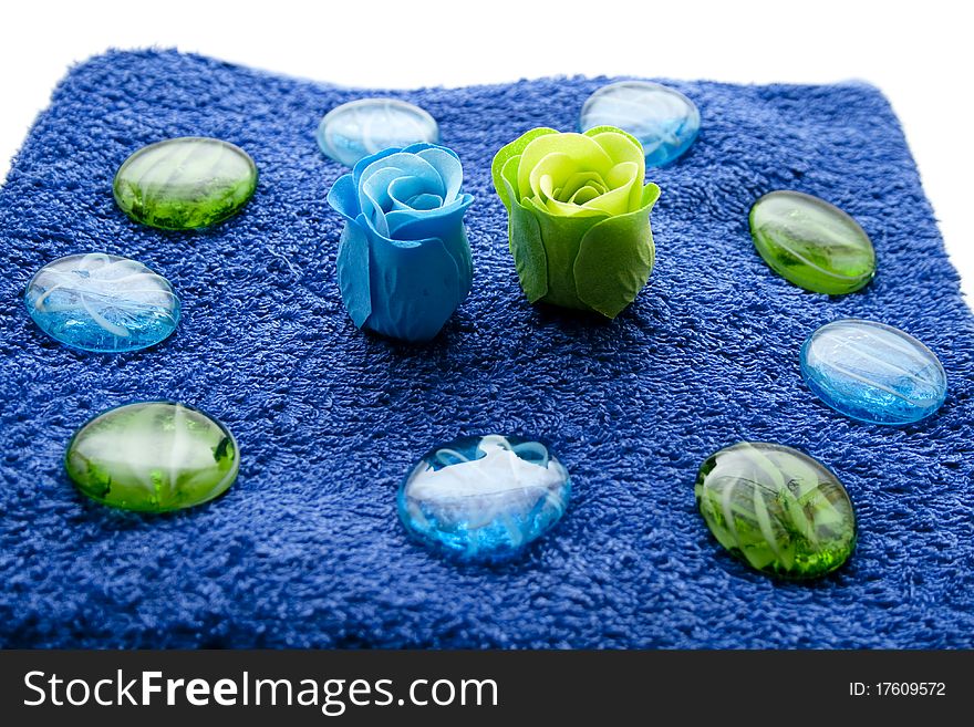 Blossoms and glass stones on blue towel