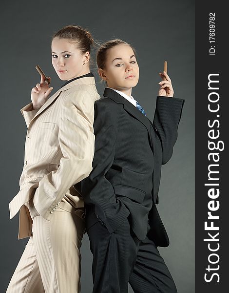 Two young girls with a cigar in man's suits. Two young girls with a cigar in man's suits