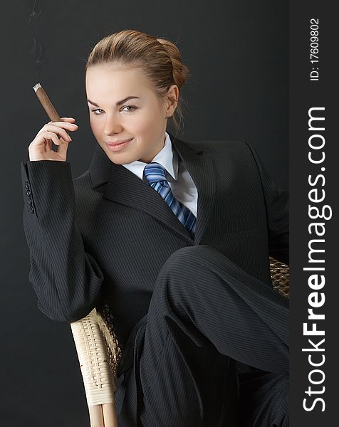 Portrait of the young woman in a man's suit with a cigar. Portrait of the young woman in a man's suit with a cigar