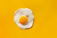 Fried Egg On Yellow Background Stock Image