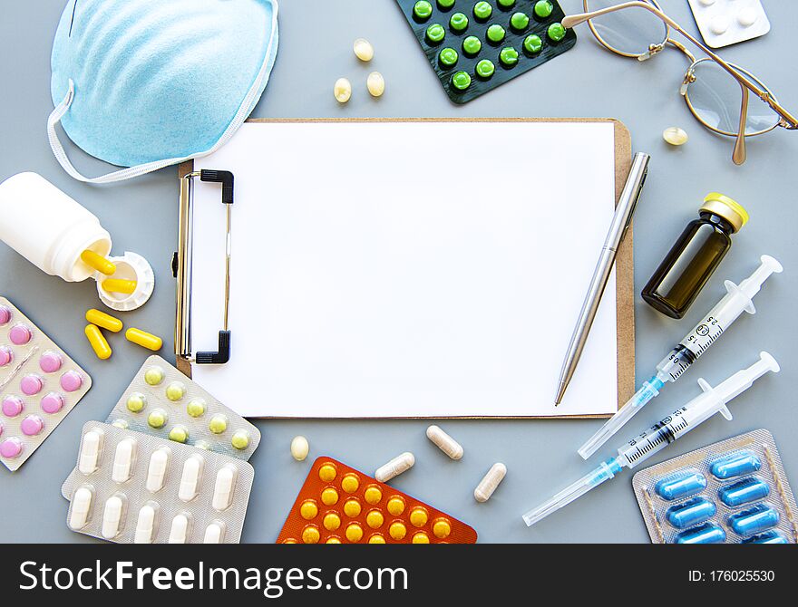 Clipboard, pharmaceutical medicine tablets, pills, capsules and medical mask.  Medicine concept. Clipboard, pharmaceutical medicine tablets, pills, capsules and medical mask.  Medicine concept