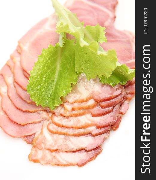 Leaf of salad and ham on a white background