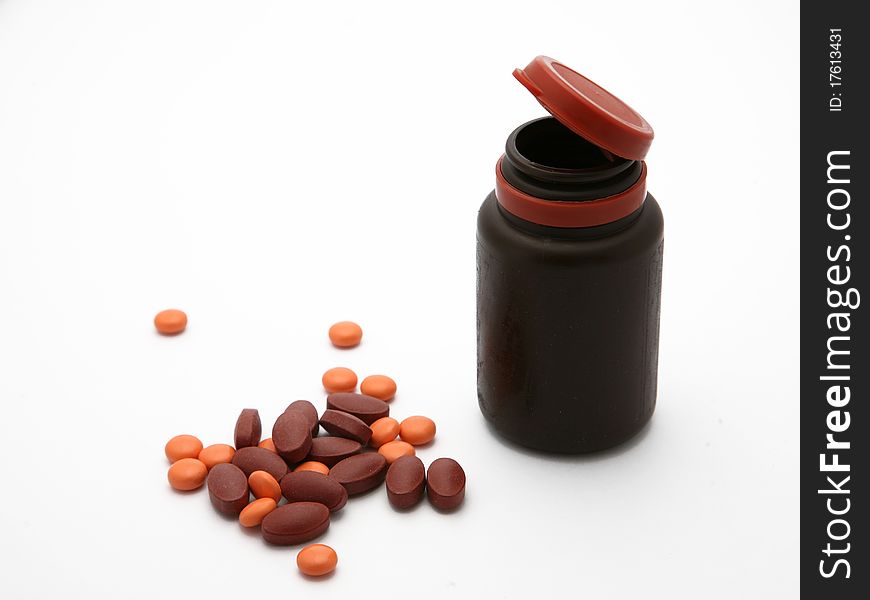 Brown orange pills spilled out of a bottle. Brown orange pills spilled out of a bottle