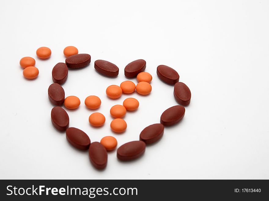Orange Brown Vitamin Pills in Heart Form. Orange Brown Vitamin Pills in Heart Form