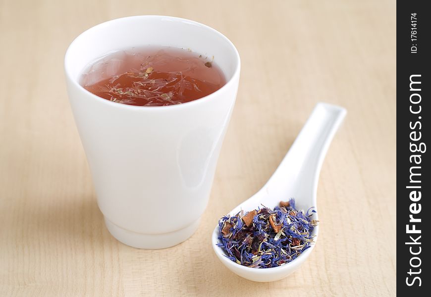 Glass of tea with different tea leaves in spoon