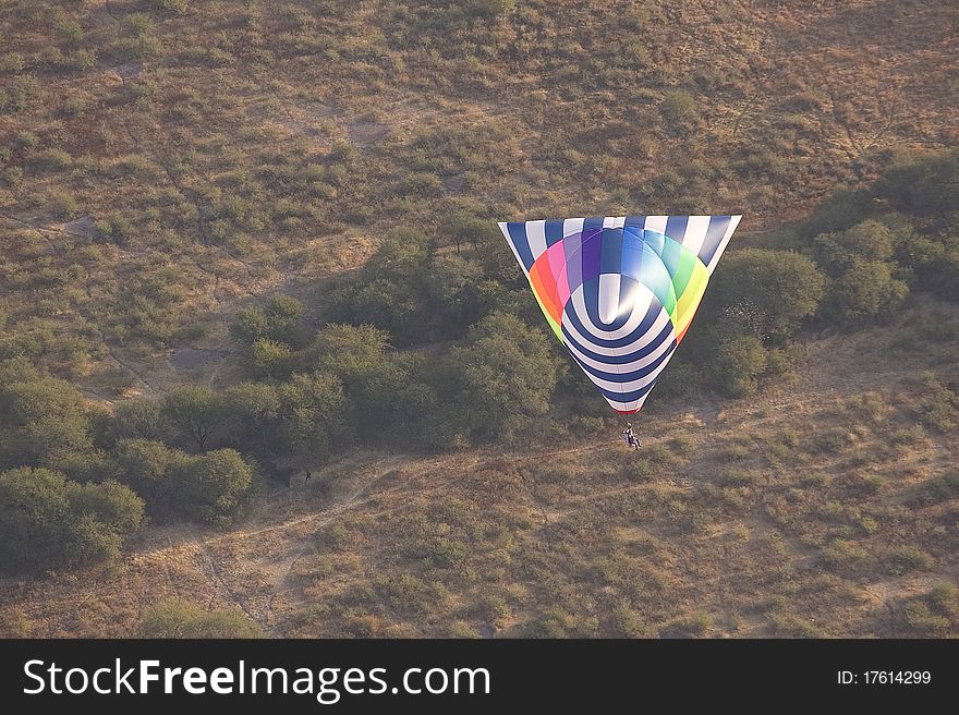 Tetrahedron shaped hot air balloon flying over desert